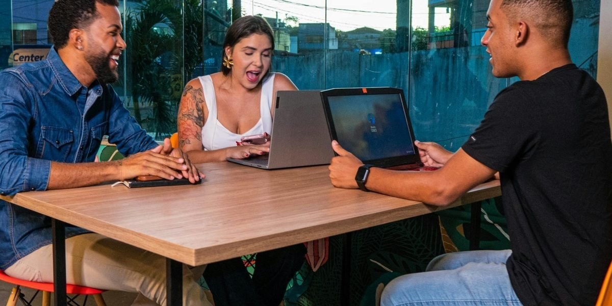 Sales team collaborating around a laptop